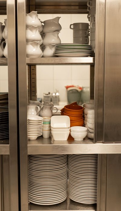 Kuchnia restauracyjna z szefem kuchni podającym danie, content zza kulis pokazujący rzemiosło i energię profesjonalnej kuchni na potrzeby social media